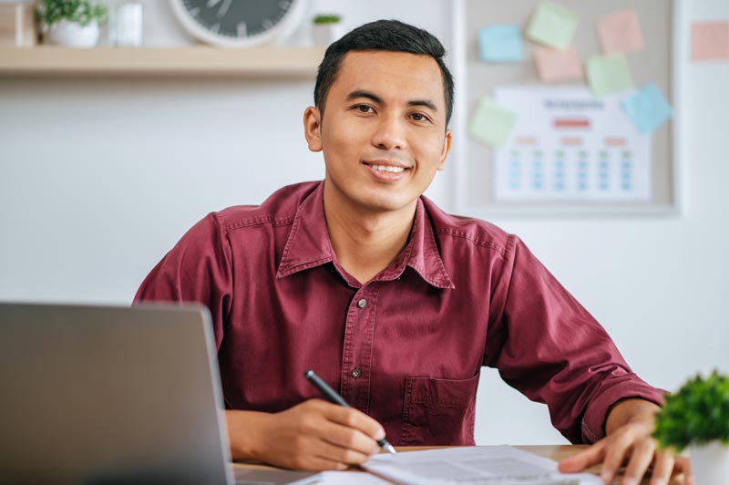 man working office with papers laptop desk.jpg